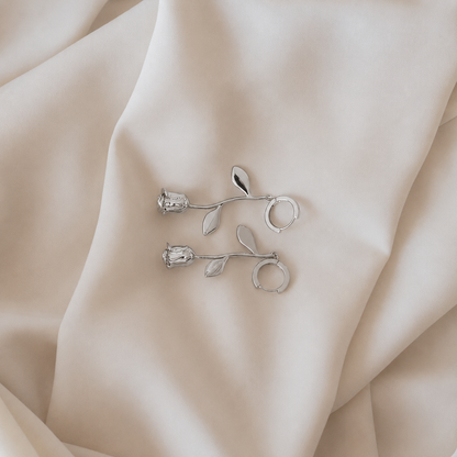 Silver floral earrings on beige fabric