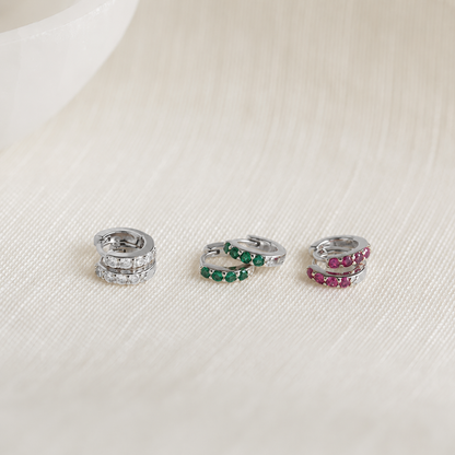 Three silver rings with gemstones on a light fabric background