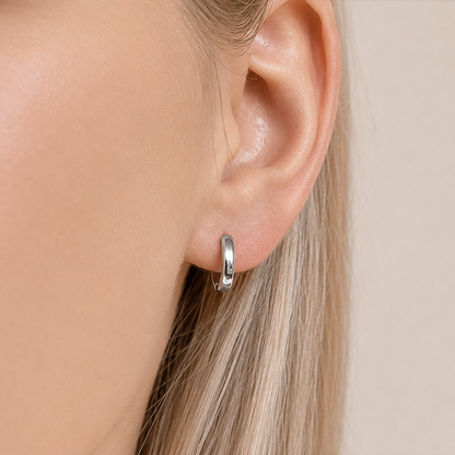 Silver hoop earring worn by a person with blonde hair.