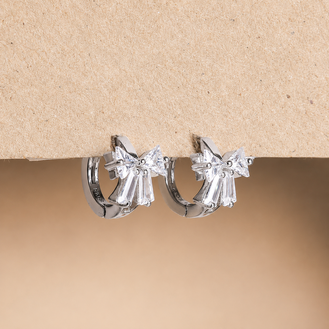 Diamond hoop earrings on a beige background