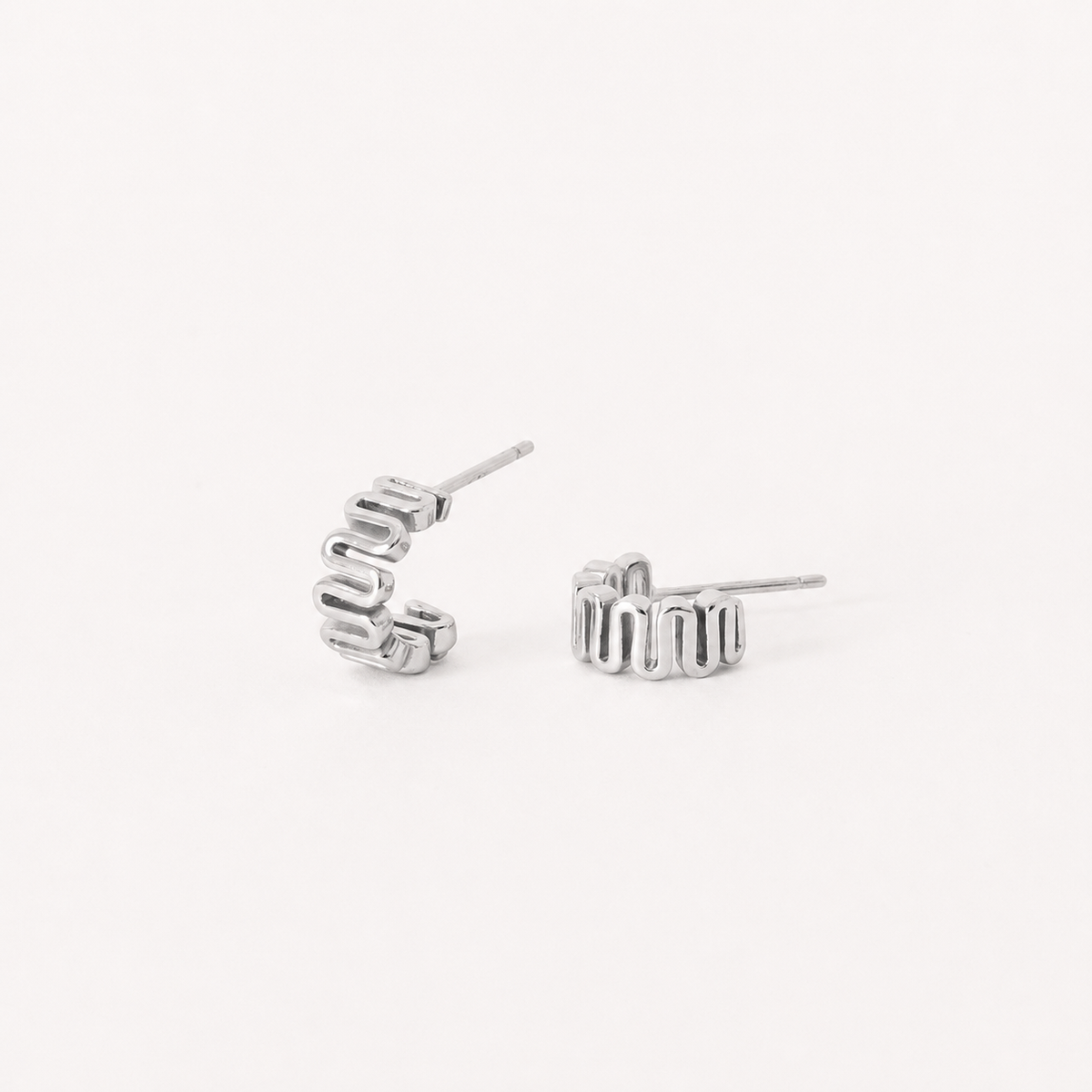 Silver hoop earrings on a light gray background