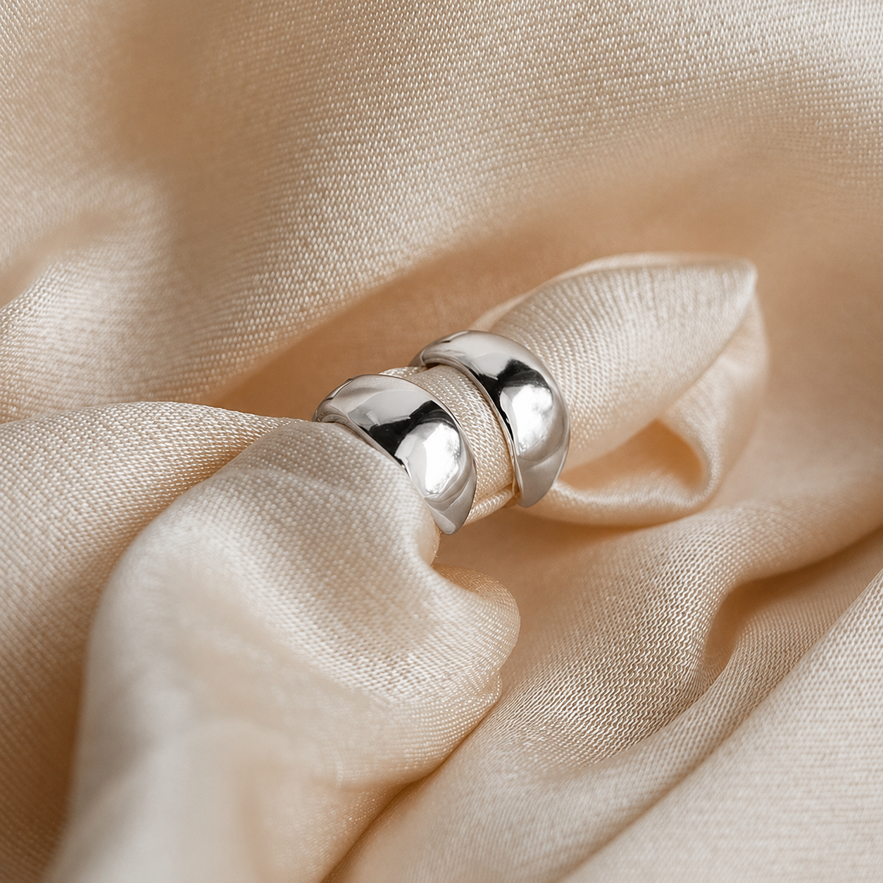 Silver ring on a beige fabric background