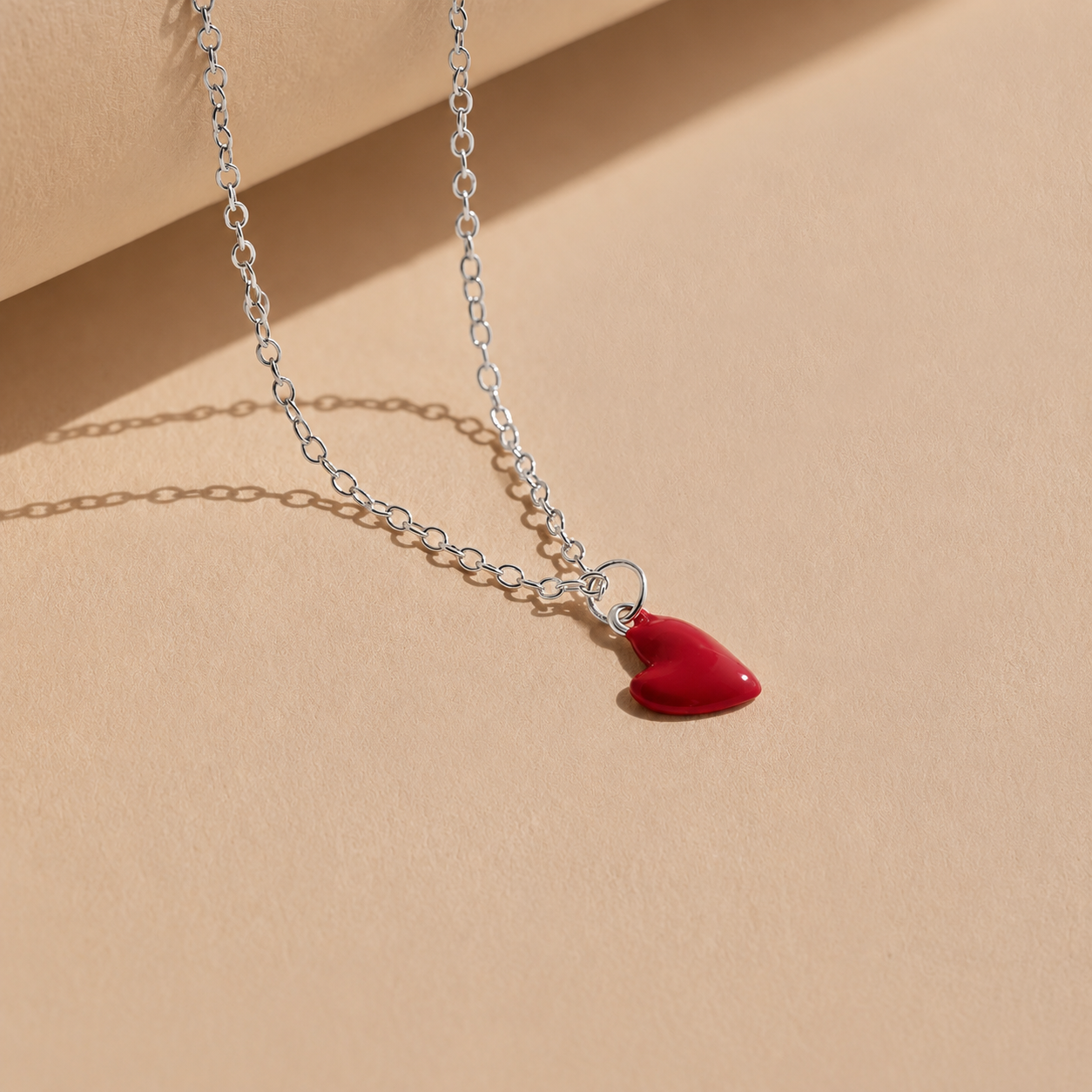 Necklace with a red heart pendant on a beige background