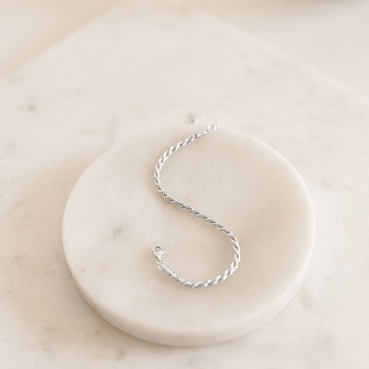 Silver bracelet on a white marble surface