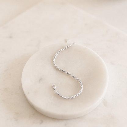 Silver bracelet on a white marble surface