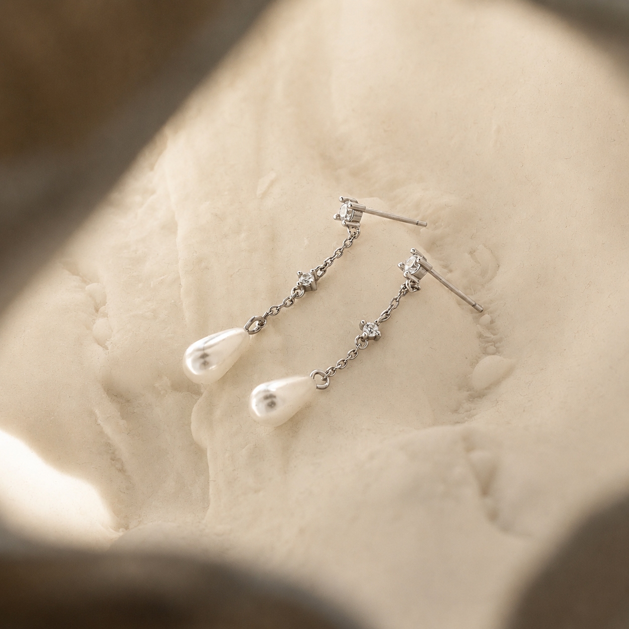 Silver earrings with pearls on a mannequin head