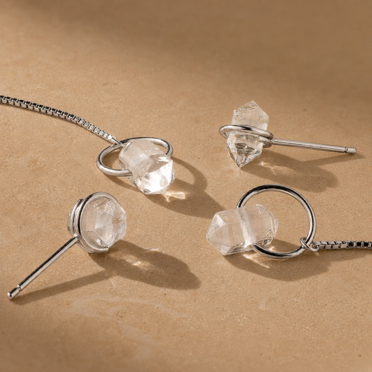 Silver jewelry set with crystal-like stones on a beige background