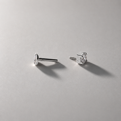 Pair of silver stud earrings on a gray background