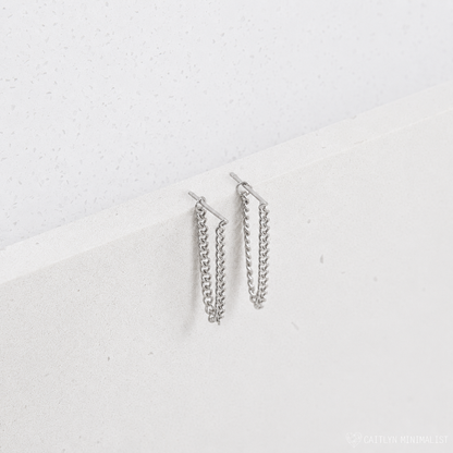 Pair of silver chain earrings on a light gray background