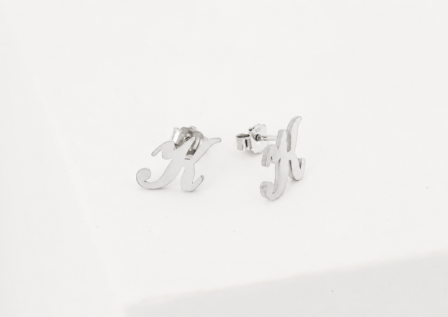 Silver earrings with letter 'M' and 'Y' on a white background