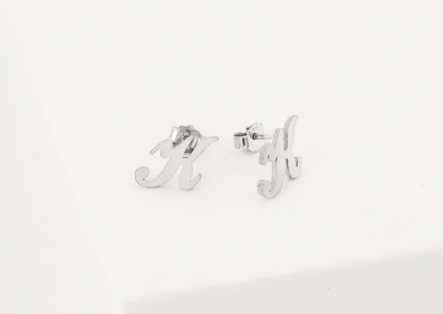 Silver earrings with letter 'M' and 'Y' on a white background
