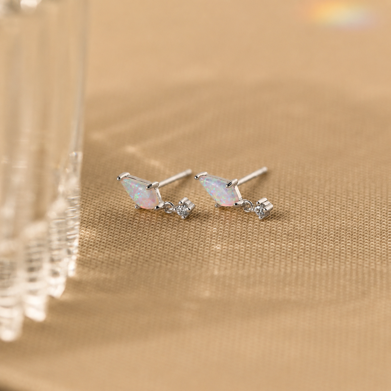 Pair of butterfly-shaped earrings with gemstones on a gold background