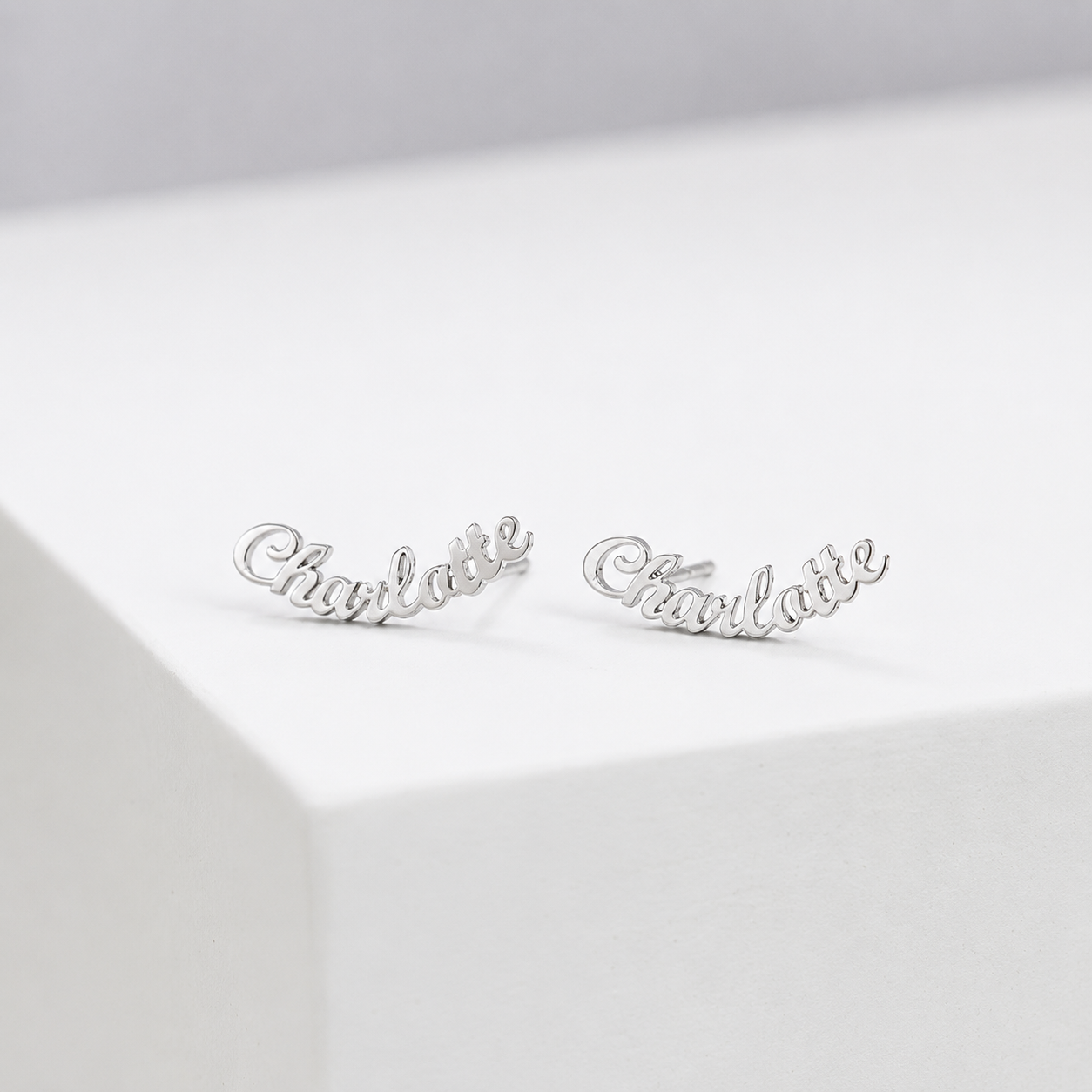 Silver 'Charlotte' earrings on a light gray background