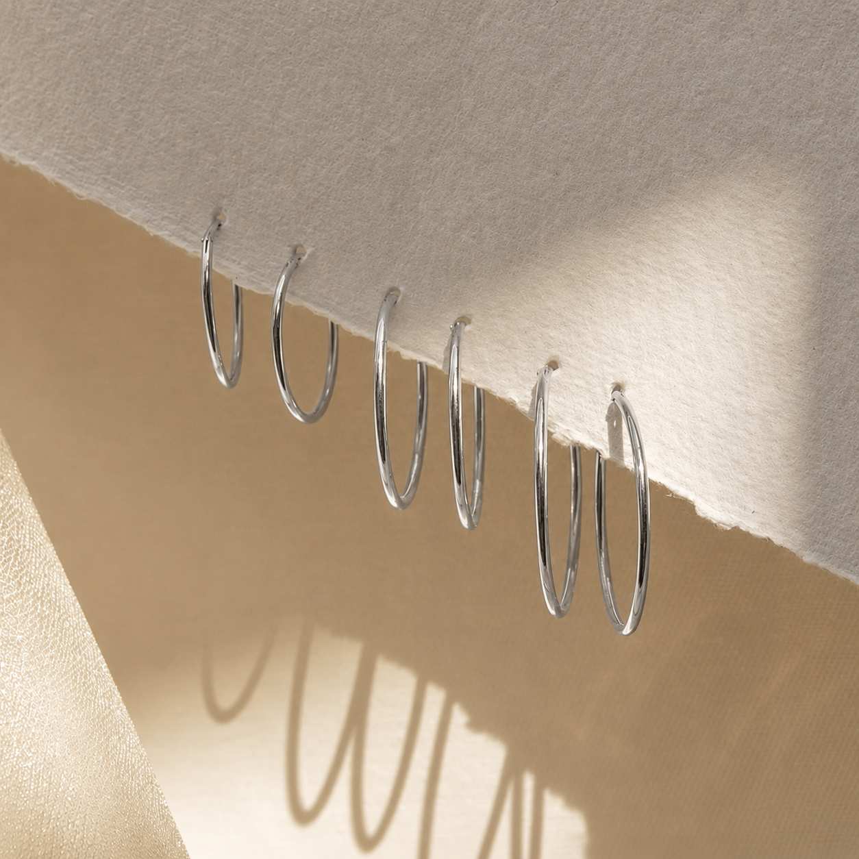 Silver hooks on a beige fabric background